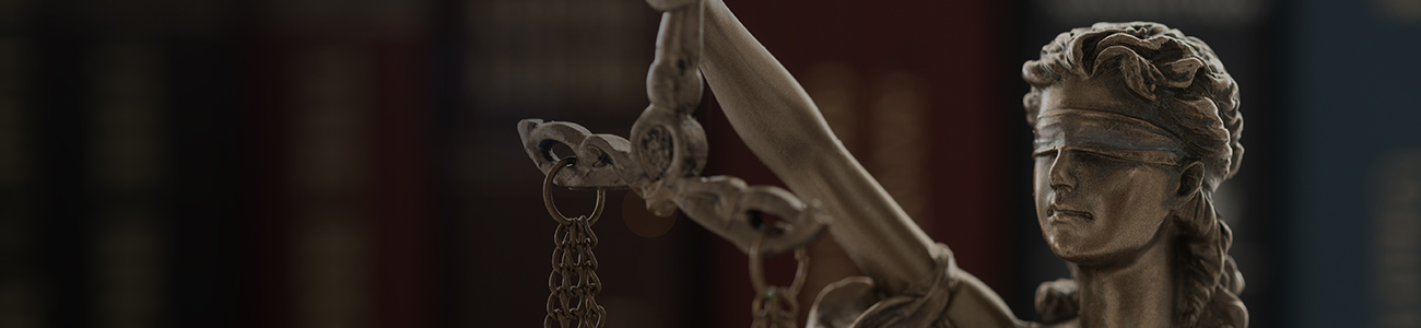 A statue of Lady Justice, blindfolded, holding a balanced scale in her right hand, symbolizing fairness and law.